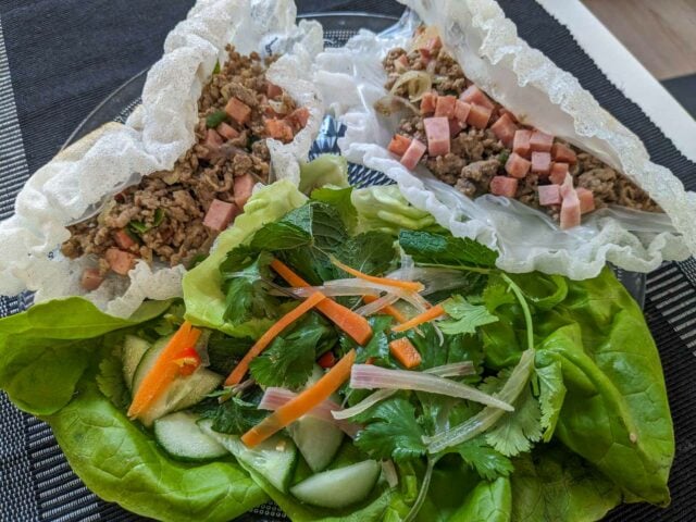 Pak mo krob - Vietnamese crispy rice paper wraps filled with pork and sausage, served with lettuce and herbs